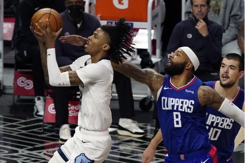 Memphis Grizzlies guard Ja Morant, left, drives past Los Angeles Clippers forward Marcus Morris Sr. (8) during the first half of an NBA basketball game Wednesday, April 21, 2021, in Los Angeles. (AP Photo/Marcio Jose Sanchez)