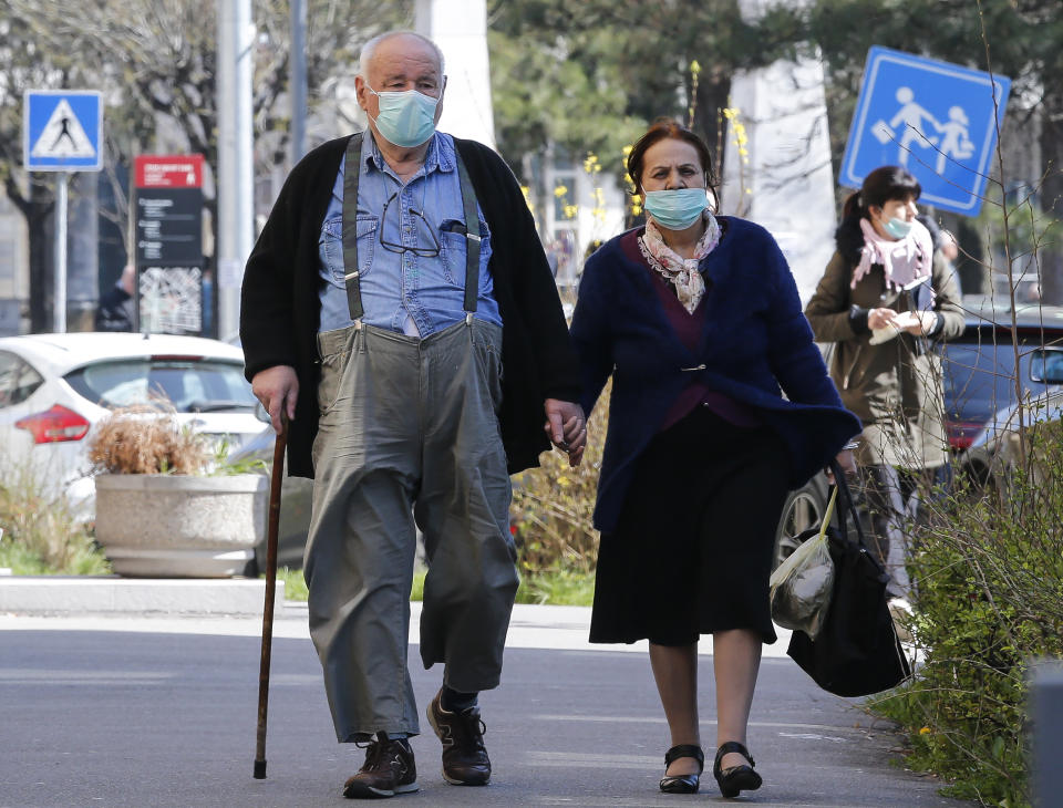 BELGRADE, SERBIA - 17 MARCH: An elderly couple wear protective masks in Belgrade on March 16, 2020 in Belgrade, Serbia. Serbian President Aleksandar Vucic had declared the state of emergency to stop the spread of the coronavirus on march 15th, 2020. Many public spaces are shut and soldiers are guarding hospitals. (Photo by Srdjan Stevanovic /Getty Images)