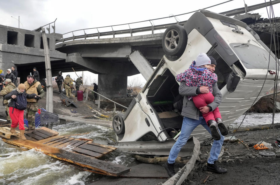 People cross an improvised path under a destroyed bridge while fleeing the town of Irpin close to Kyiv, Ukraine, Monday, March 7, 2022. Russia announced yet another cease-fire and a handful of humanitarian corridors to allow civilians to flee Ukraine. Previous such measures have fallen apart and Moscow’s armed forces continued to pummel some Ukrainian cities with rockets Monday. (AP Photo/Efrem Lukatsky)