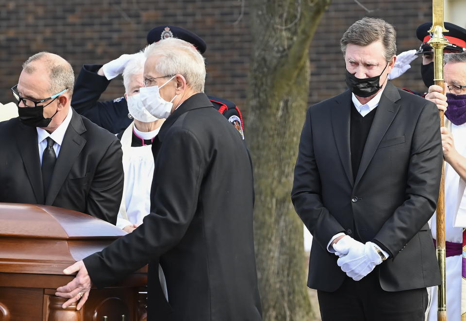 Hockey hall-of-fame legend Wayne Gretzky, right, watches the casket of his father, Walter Gretzky, as it is carried from the church during a funeral service in Brantford, Ontario, Saturday, March 6, 2021. Walter Gretzky, also known as Canada's hockey dad was 82 years old. (Nathan Denette/The Canadian Press via AP)