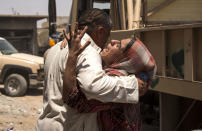 <p>An Iraqi man comforts a relative, who fled the fighting between government forces and Islamic State (IS) group jihadists in the Old City of Mosul, as they wait to be relocated in the city’s western industrial district, on July 8, 2017. (Photo: Fadel Senna/AFP/Getty Images) </p>