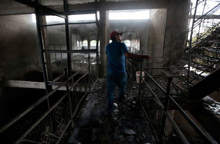 A man stands inside a burned house where, according to local media, six people died, during a protest against Nicaragua's President Daniel Ortega's in Managua, Nicaragua June 16, 2018. REUTERS/Oswaldo Rivas