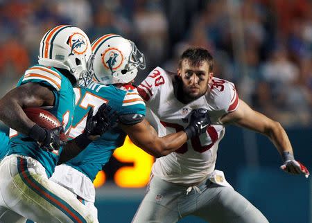 Dec 14, 2015; Miami Gardens, FL, USA; New York Giants safety Taylor Cooper (30) is blocked by Miami Dolphins Shamiel Gary as Miami running back Jarvis Landry (14) carries in the first half at Sun Life Stadium. Mandatory Credit: Andrew Innerarity-USA TODAY Sports