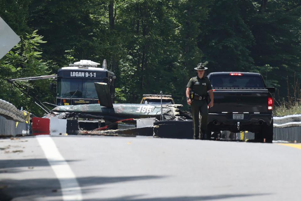 Emergency personnel look over the sight of a  helicopter that crashed in Blair, W.Va., on Thursday, June, 23, 2022.  A Vietnam-era helicopter was used for tourism flights and crashed along Route 17 in Logan County about 5 p.m. Wednesday. County emergency ambulance service executive Ray Bryant says all six on board were killed.(AP Photo/Chris Jackson)