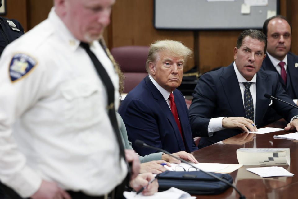 Trump with his attorneys Joe Tacopina and Boris Epshteyn, far right, during his arraignment at the Manhattan Criminal Court