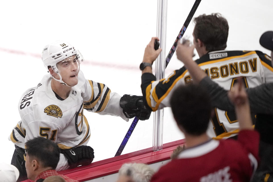 Boston Bruins' Matthew Poitras looks at a celebrating Bruins fan after Poitras scored on Chicago Blackhawks goaltender Petr Mrazek during the third period of an NHL hockey game Tuesday, Oct. 24, 2023, in Chicago. (AP Photo/Charles Rex Arbogast)