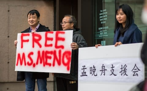 People hold signs in support of Meng Wanzhou, chief financial officer of Huawei Technologies Co., outside of a bail hearing at the Supreme Court in Vancouver - Credit: Bloomberg