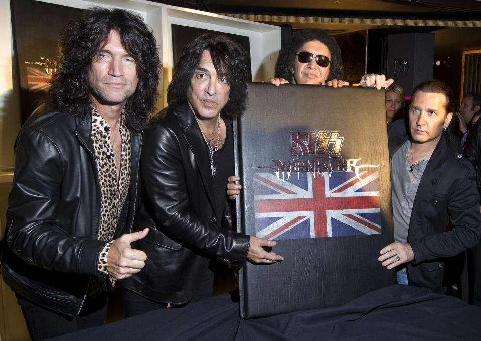 U.S rock band KISS members, from left, Tommy Thayer, Paul Stanley, Gene Simmons and Eric Singer, with their new book 'Monster' which contains photographs of the band's 40 year career live on stage, following a press conference in London, ahead of a concert on July 4 in aid of Help For Heroes. (AP Photo/Joel Ryan)