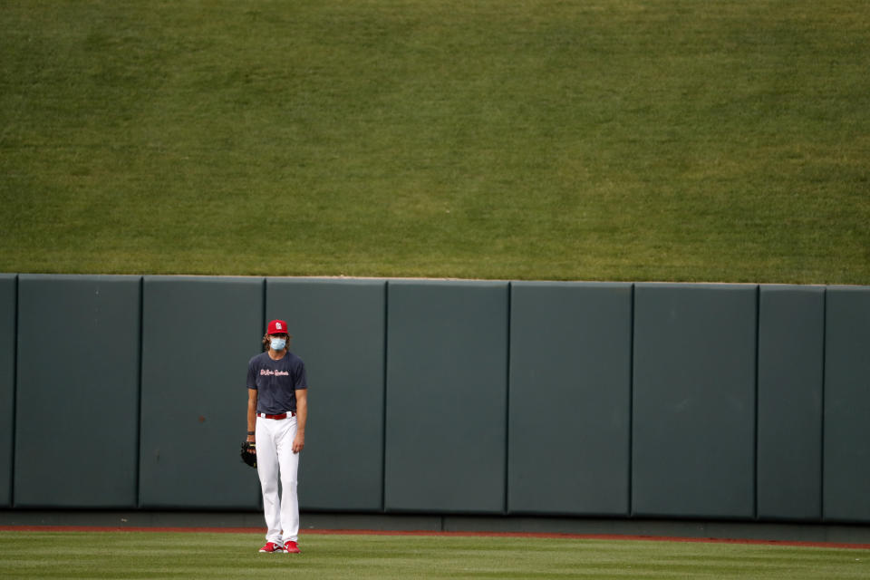 St. Louis Cardinals pitcher Andrew Miller wears a face mask as he stands in the outfield during baseball practice at Busch Stadium Wednesday, July 8, 2020, in St. Louis. (AP Photo/Jeff Roberson)