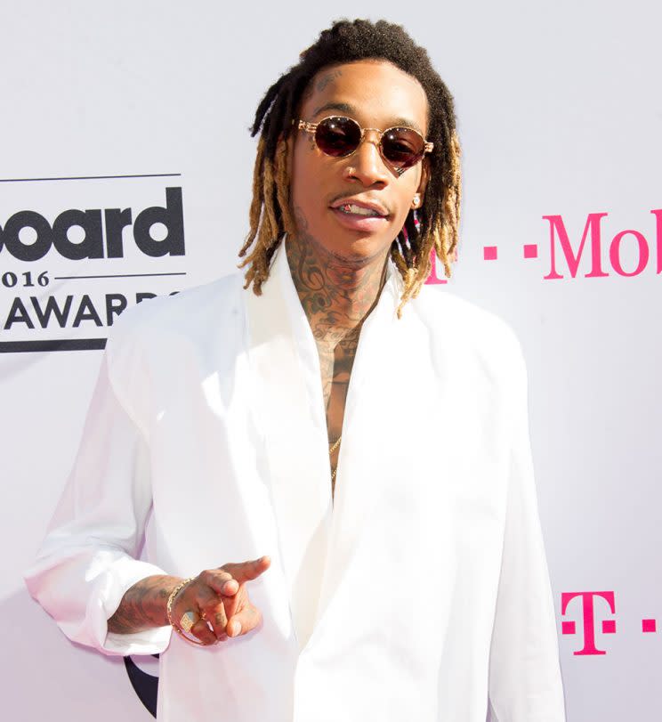 Wiz Khalifa gives a low peace sign