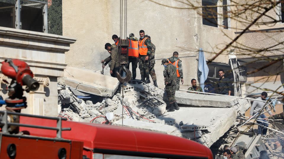 Security and emergency personnel search the rubble of a building destroyed in Damascus on January 20, 2024. - Louai Beshara/AFP/Getty Images