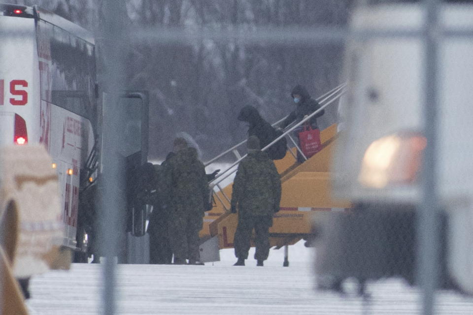 Passengers step off a plane carrying Canadians back from the Wuhan province in China, after arriving at Canadian Forces Base Trenton in Trenton, Ont., on Friday Feb. 7, 2020. (Lars Hagberg/The Canadian Press via AP)