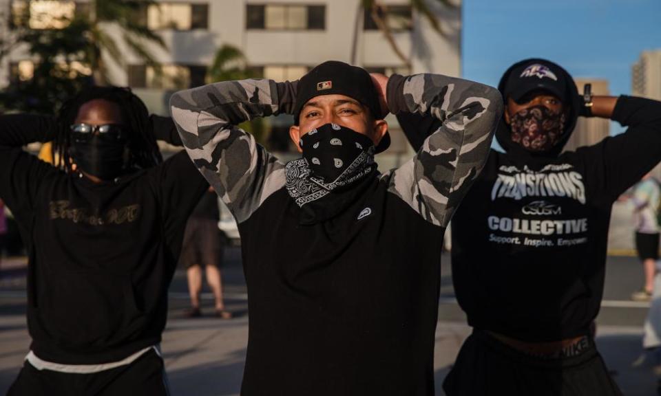 Demonstrators stand in front of San Diego police on Sunday.