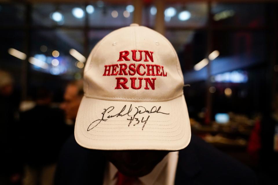 Leon Benjamin, of Va., displays his autographed hat during an election night watch party for Republican candidate Herschel Walker, Tuesday, Dec. 6, 2022, in Atlanta.