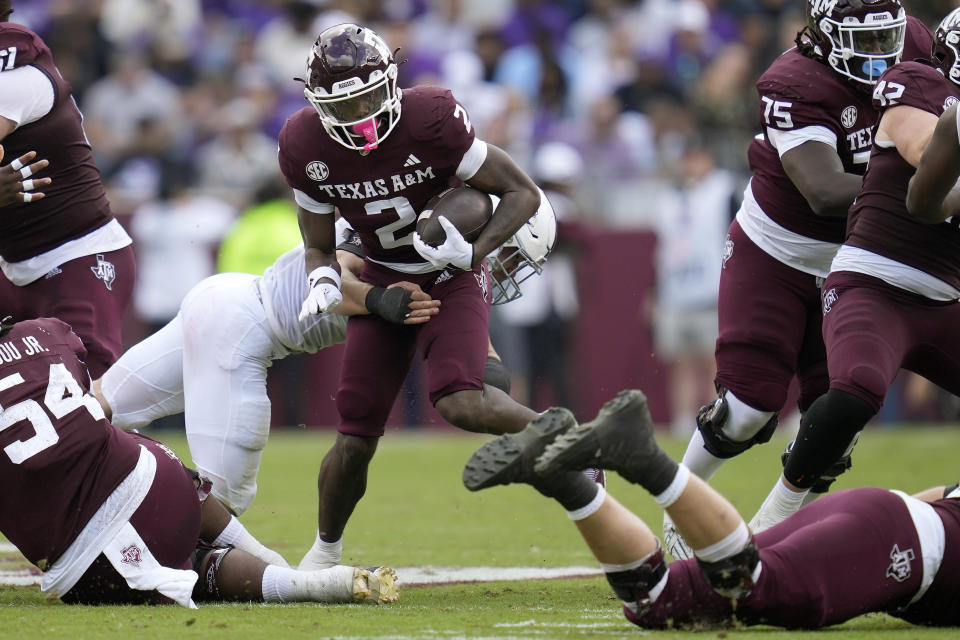 Texas A&M running back Rueben Owens (2) breaks a tackle attempt by a Abilene Christian defender for a 26-yard run during the second quarter of an NCAA college football game Saturday, Nov. 18, 2023, in College Station, Texas. (AP Photo/Sam Craft)