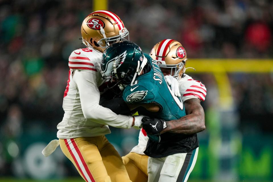 Philadelphia Eagles wide receiver DeVonta Smith, center, is stopped by San Francisco 49ers cornerback Ambry Thomas, left, and linebacker Dre Greenlaw during the second half of an NFL football game, Sunday, Dec. 3, 2023, in Philadelphia. (AP Photo/Matt Slocum)
