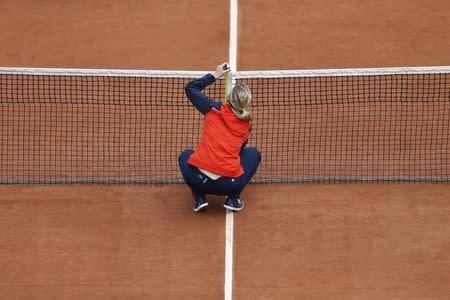 A referre measures the net before the start of a women's single match between Dominika Cibulkova of Slovakia and Virginie Razzano of France at the French Open tennis tournament at the Roland Garros stadium in Paris May 26, 2014. REUTERS/Vincent Kessler