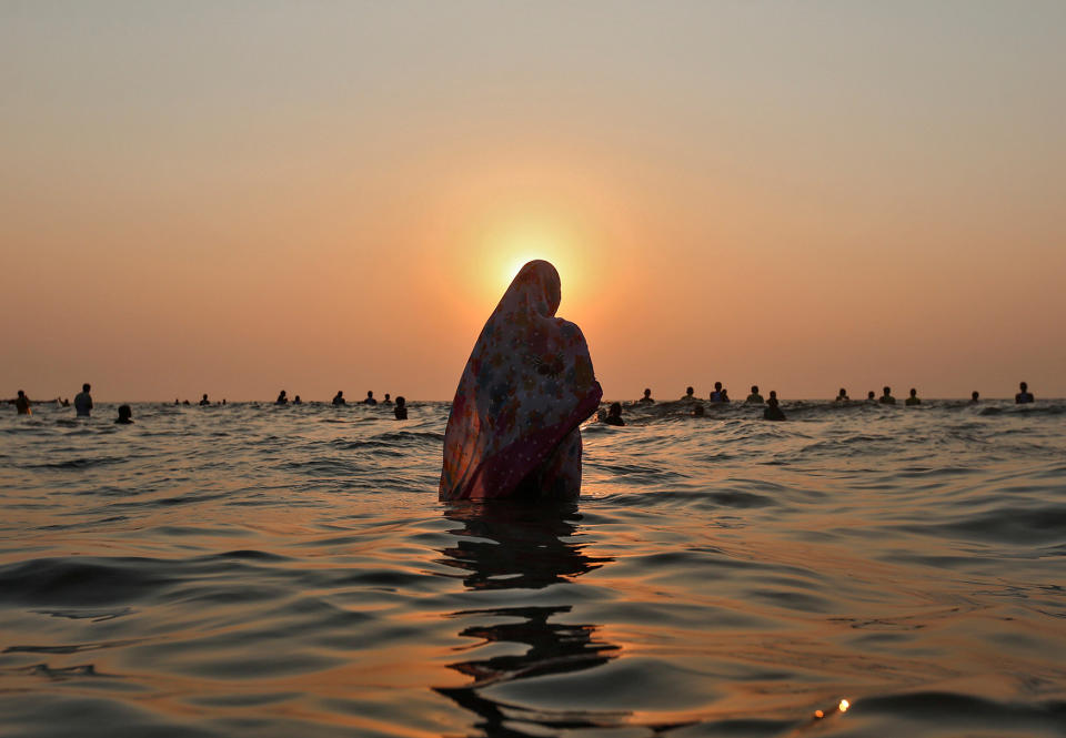 Hindu devotees worship the Sun god in the waters of the Arabian Sea