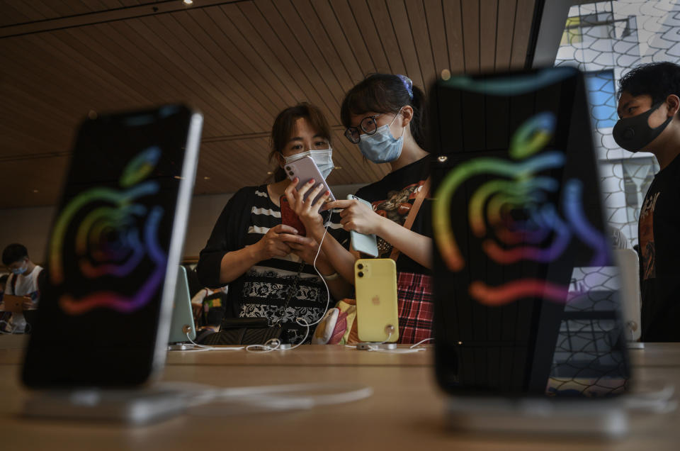 BEIJING, CHINA - JULY 17:  Chinese customers look at iphones at the official opening of the new Apple Store in the Sanlitun shopping area on July 17, 2020 in Beijing, China. The new store replaces Apple's first ever China store which opened in 2008 prior to the Beijing Olympics adjacent to the new location. Chinas economy returned to growth in the second quarter of 2020, after historic declines in the first quarter due to the coronavirus pandemic. According to figures released by the government Thursday, the gross domestic product grew 3.2% in the quarter from a year ago, reversing a 6.8% contraction in the first part of the year as the country battled the outbreak. (Photo by Kevin Frayer/Getty Images)