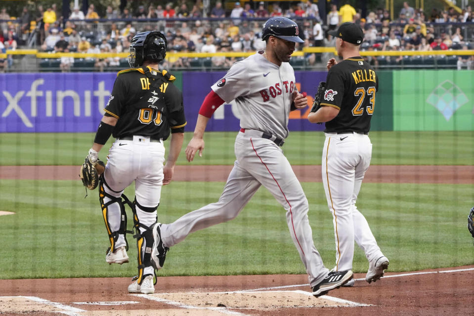 Boston Red Sox's J.D. Martinez, center, next to Pittsburgh Pirates starting pitcher Mitch Keller (23) and catcher Jason Delay on a hit by Eric Hosmer during the first inning of a baseball game Tuesday, Aug. 16, 2022, in Pittsburgh. (AP Photo/Keith Srakocic)