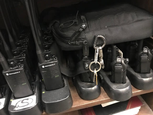 Radios with the D. Sterling Security logo charging in the 18th Precinct community affairs office. The radio bag has office keys attached so that employees of the company could access the office freely, former NYPD detective Lance Trent said.