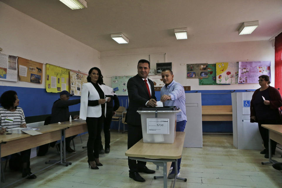 Macedonian Prime Minister Zoran Zaev, centre, accompanied by his wife Zorica, left and his son Dusko, right, casts his ballot at a polling station during a referendum in Strumica, southeastern Macedonia, Sunday, Sept. 30, 2018. Macedonians were deciding Sunday on their country's future, voting in a crucial referendum on whether to accept a landmark deal ending a decades-old dispute with neighbouring Greece by changing their country's name to North Macedonia, to qualify for NATO membership and also pave its way toward the European Union. (AP Photo/Boris Grdanoski)