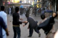 pakistani Shiite and Sunni Muslims throw stones at each other during a clash at an Ashura procession in Rawalpindi on November 15, 2013
