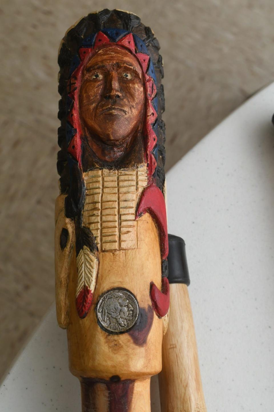 Earl Dugger carved the head of a Native American tribal chief on one of his walking sticks. Each stick and walking cane he makes is adorned with a real Buffalo nickel in the handle.