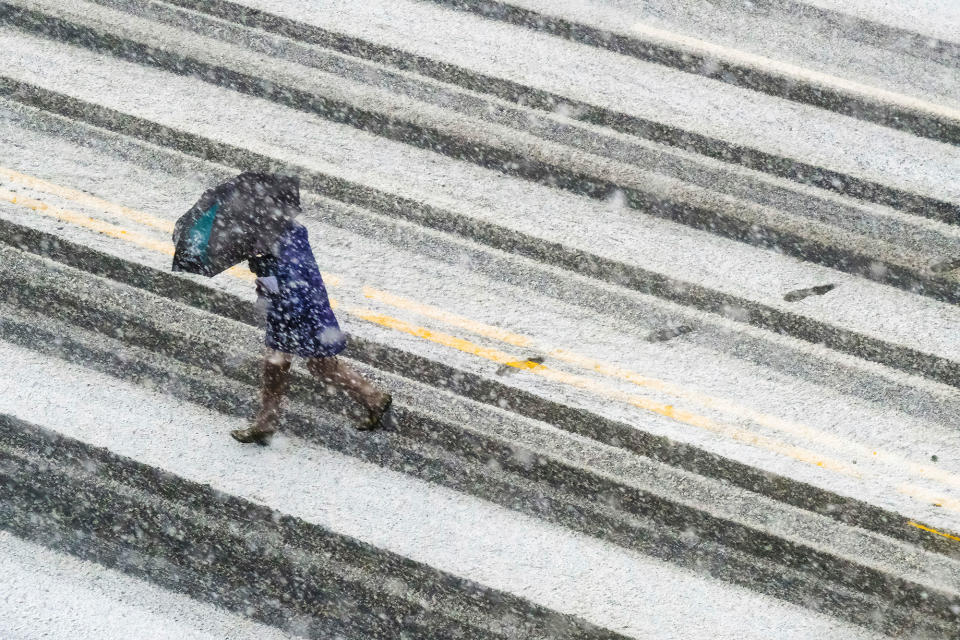 <p>A pedestrian races across the snow covered and tire streaked street in Washington during a spring storm, Wednesday, March 21, 2018. (Photo: J. David Ake/AP) </p>