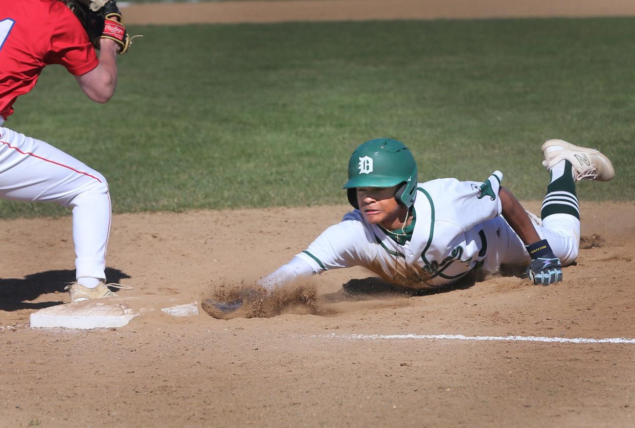 Dover freshman Amari Lewis dives back into first base on a pickoff attempt during Friday's Division I game against Winnacunnet.