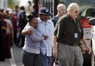 Navy Yard workers evacuated after the shooting are reunited with loved ones at a makeshift Red Cross shelter at the Nationals Park baseball stadium near the affected naval installation in Washington, September 16, 2013. (REUTERS/Jonathan Ernst)