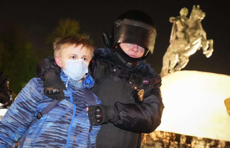 FILE - Policeman detain a young demonstrator during an action against Russia's attack on Ukraine in St. Petersburg, Russia, Monday, Feb. 28, 2022. Eight months after Russian President Vladimir Putin launched an invasion against Ukraine expecting a lightening victory, the war continues, affecting not just Ukraine but also exacerbating death and tension in Russia among its own citizens. (AP Photo/Dmitri Lovetsky, File)