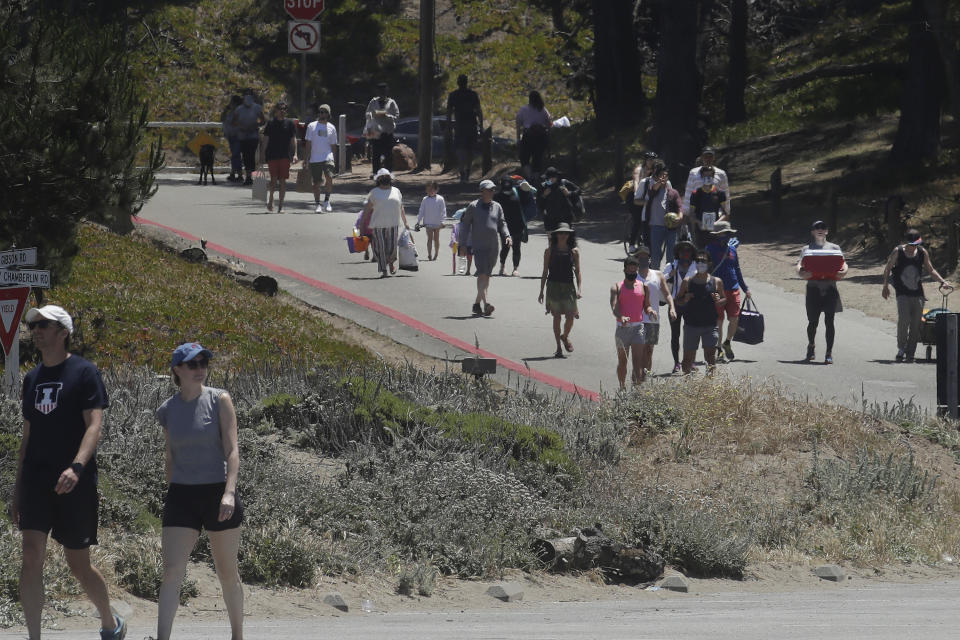People walk down a road closed to cars while visiting Baker Beach during the coronavirus outbreak in San Francisco, Sunday, May 24, 2020. (AP Photo/Jeff Chiu)