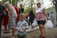 Ukrainian refugees from the Donetsk region receive food as humanitarian aid on the outskirts of the southern coastal town of Mariupol September 10, 2014. REUTERS/Vasily Fedosenko