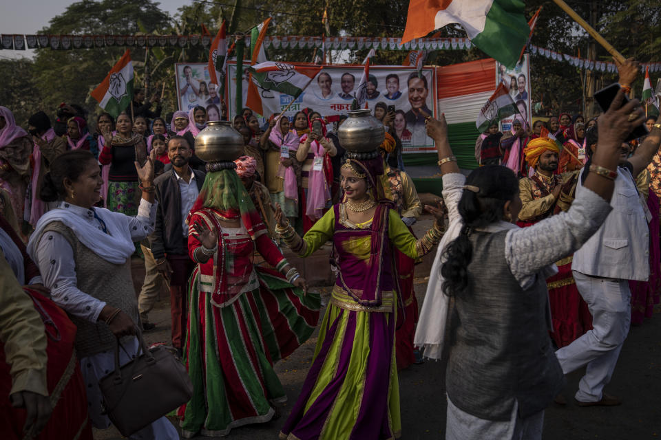 Artists dance as people watch from the sidewalks while Rahul Gandhi march with his supporters in New Delhi, India, Saturday, Dec. 24, 2022. Rahul Gandhi, leader of India's beleaguered opposition Congress party, on Saturday marched in New Delhi along with his supporters, part of his five-month-long 3,570km (2,218-mile) countrywide trek through 12 states that began 105 days ago.(AP Photo/Altaf Qadri)