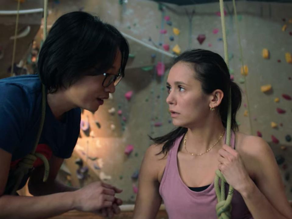 Jimmy O. Yang and Nina Dobrev at an indoor rock climbing wall in "Love Hard."