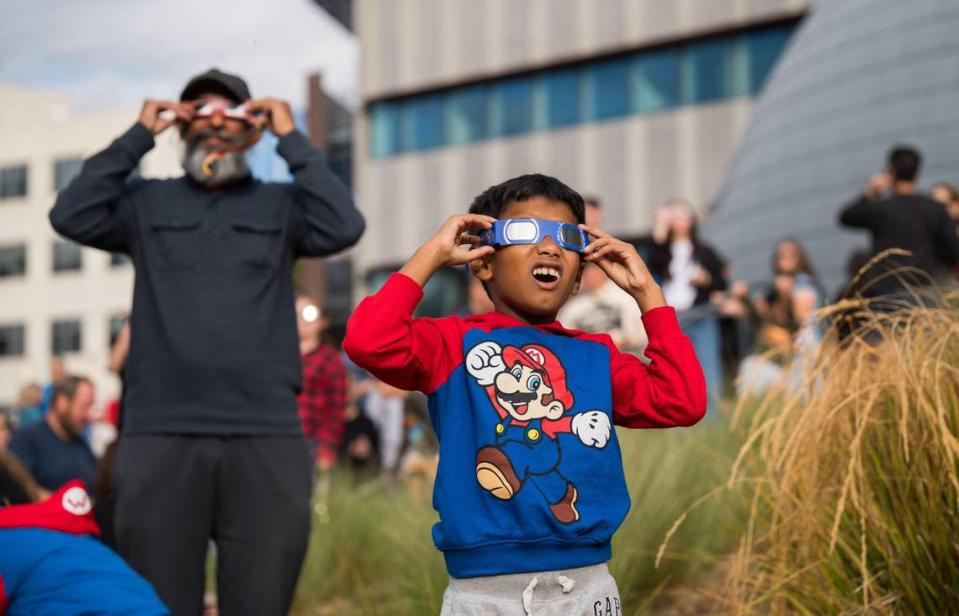 Anay Lankalapalli, 7, of Sacramento, watches the rare annular solar eclipse Saturday, Oct. 14, 2023, at an event hosted at Sacramento State’s planetarium. Anay watched with his family and friends from the Brookfield School while the partial eclipse was intermittently visible through drifting clouds across the Northern California skies.