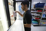 Hardik Kalra stocks meat in a cooler at a local super market, Friday, May 29, 2020, in Des Moines, Iowa. As if trips to the grocery store weren't nerve-racking enough, shoppers lately have seen the costs of meat, eggs and even potatoes soar as the coronavirus has disrupted processing plants and distribution networks. (AP Photo/Charlie Neibergall)