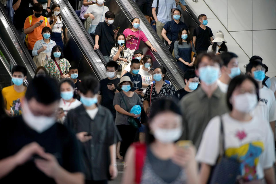 Image: People wearing protective masks ride escalators inside a subway station, following new cases of the coronavirus disease (COVID-19), in Shanghai (Aly Song / Reuters)