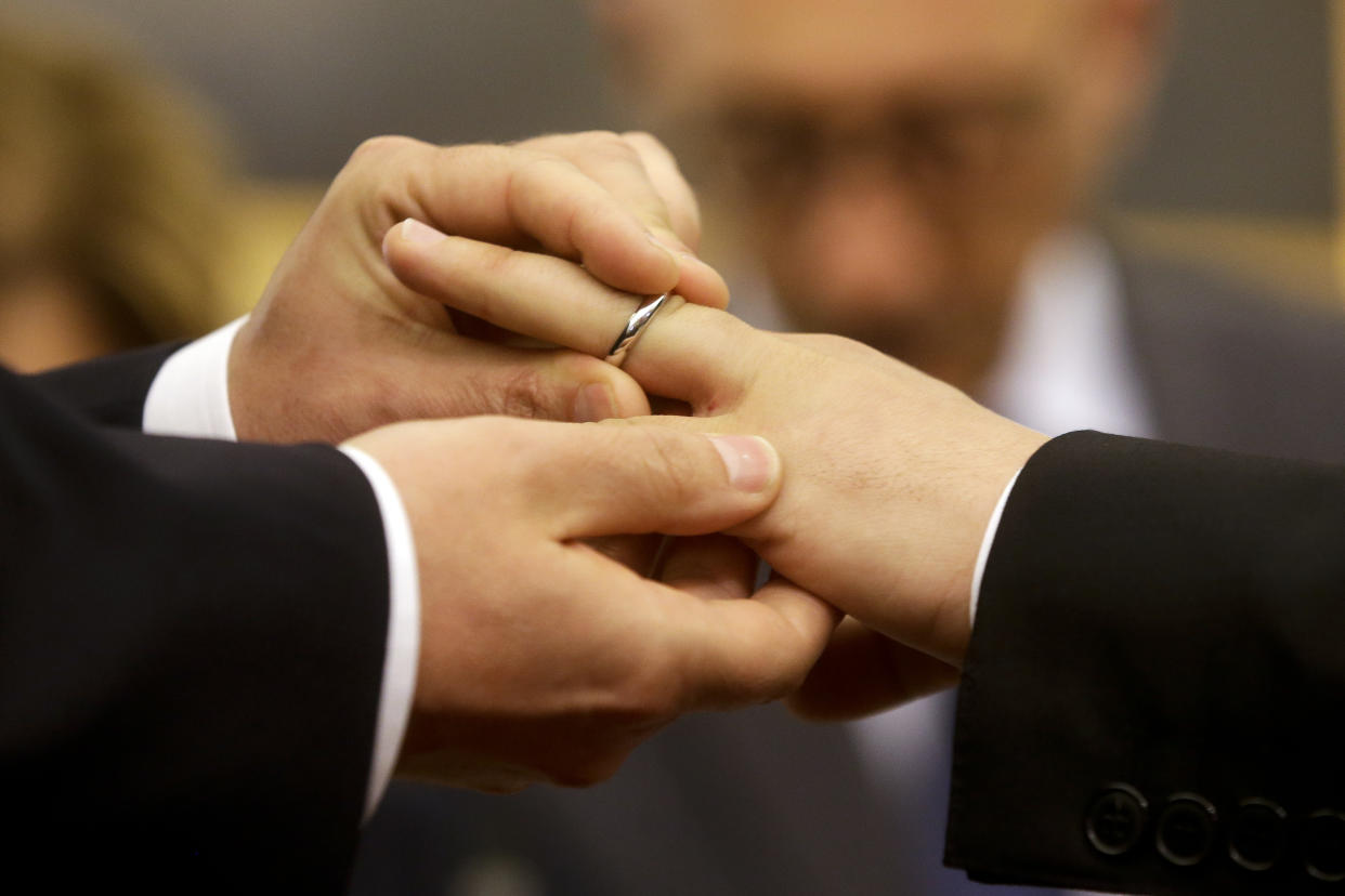 FILE - In this May 21, 2015 file photo, Mauro Cioffari, left, puts a wedding ring on his partner Davide Conti's finger as their civil union is being registered by a municipality officer during a ceremony in Rome's Campidoglio Capitol Hill. In an interview with The Associated Press at The Vatican, Tuesday, Jan. 24, 2023, Pope Francis acknowledged that Catholic bishops in some parts of the world support laws that criminalize homosexuality or discriminate against the LGBTQ community, and he himself referred to homosexuality in terms of "sin." But he attributed attitudes to cultural backgrounds and said bishops in particular need to undergo a process of change to recognize the dignity of everyone. (AP Photo/Gregorio Borgia, file)