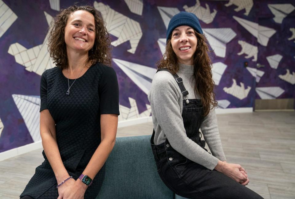 Tansley Stearns, the president and CEO of Community Financial Credit Union in the Wayne State University student center, left, poses with artist Ani Garabedian, 47, of Detroit, on Monday, Jan. 22, 2024. Stearns commissioned Garabedian to paint a mural that pays homage to a long-lost tradition of Wayne State University students throwing dagger-sharp paper airplanes at the ceiling of the student center.