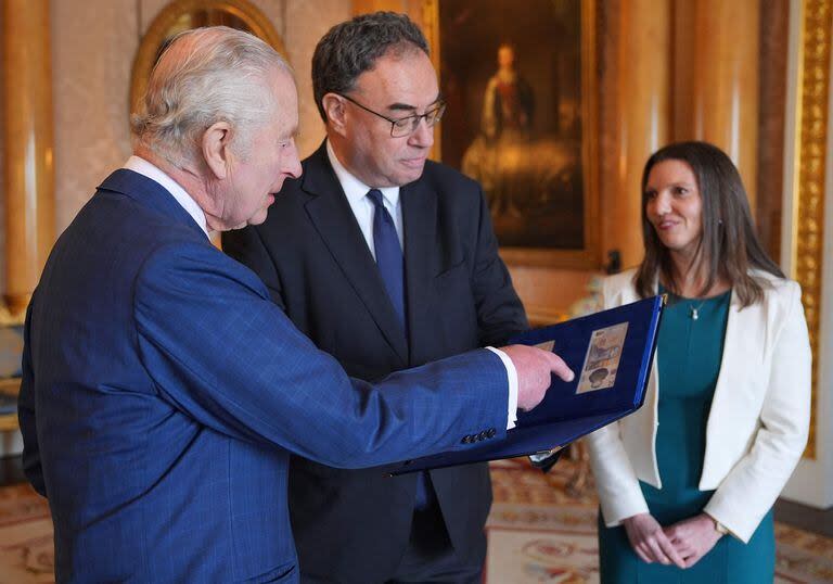 El rey Carlos III observa los billetes con su rostro (Yui Mok / POOL / AFP)