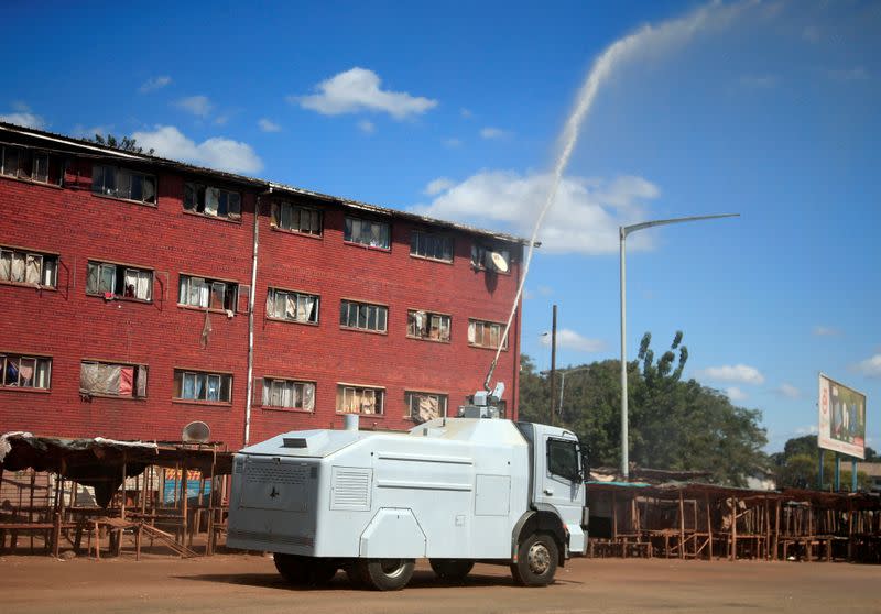 A police water canon sprays disinfectant over residential flats during a 21-day nationwide lockdown called to help curb the spread of coronavirus disease (COVID-19), in Harare