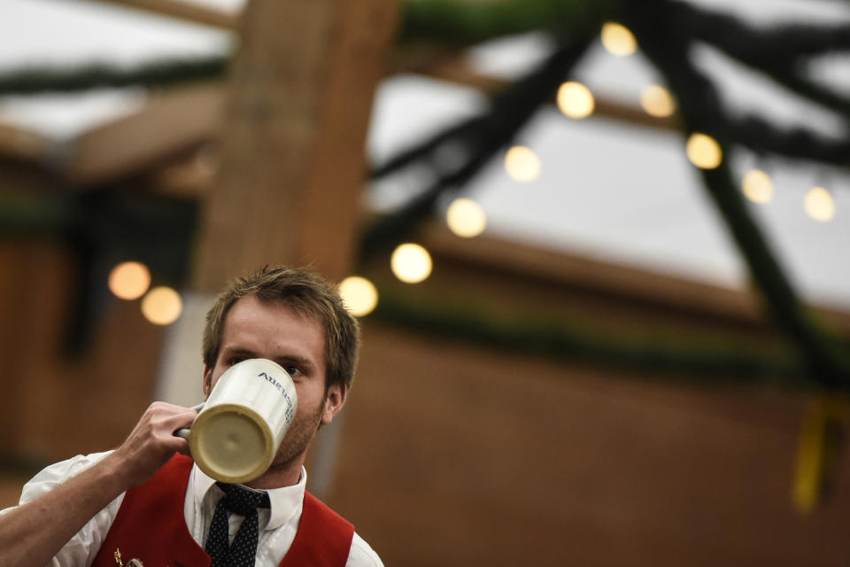 <p>A visitor drinks beer from a stone mug in the ‘Tradition’ tent (Getty Images) </p>