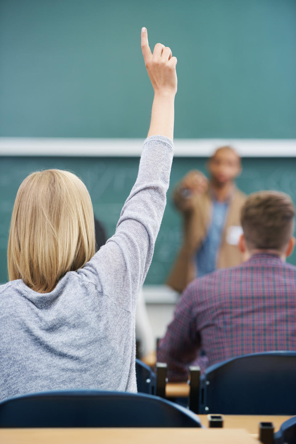 A student raises her hand during a lecture