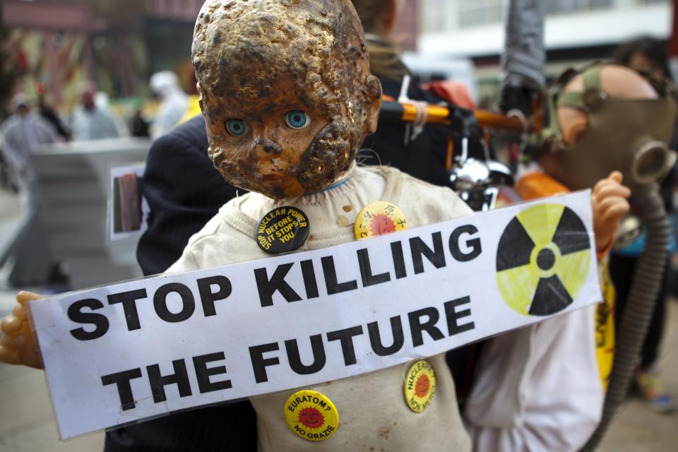 FILE - A demonstrator with puppets on his backpack attends a protest demand to shut down nuclear power plants in Berlin on Tuesday, May 17, 2011. Germany is shutting down its last three nuclear power plants on Saturday, April 15, 2023, as part of an energy transition agreed by successive governments. The final countdown, delayed for several months over feared energy shortages because of the Ukraine war, is seen with relief by Germans who have campaigned against nuclear power. (AP Photo/Markus Schreiber, File)