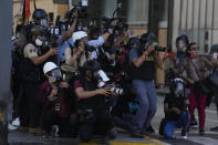 Journalists cover clashes between police and anti-government protesters in Lima, Peru, Tuesday, Jan. 24, 2023. Protesters are seeking the resignation of President Dina Boluarte, the release from prison of ousted President Pedro Castillo, immediate elections and justice for demonstrators killed in clashes with police. (AP Photo/Martin Mejia)