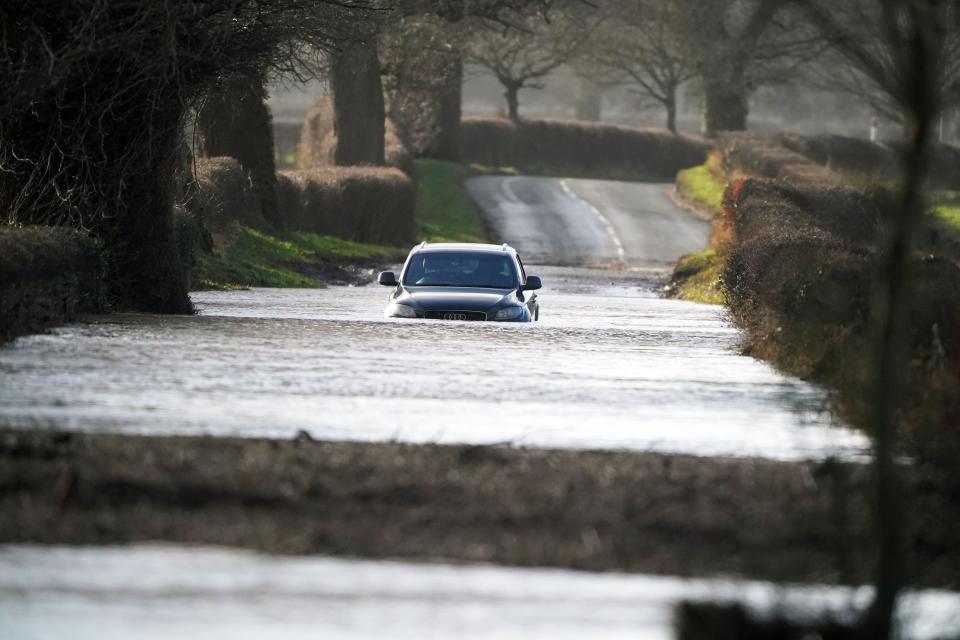 A car driving through flood water in Warwick bridge in Cumbria. Thousands of people have been left without power as Storm Isha brought disruption to the electricity and transport networks across the UK. Picture date: Monday January 22, 2024.