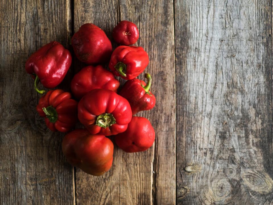 High Angle View Of Red Bell Peppers On Wooden Table