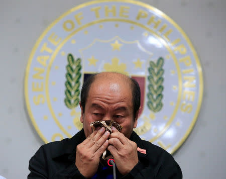 Arturo Lascanas, a retired Davao policeman, wipes his tears during a news conference at the Senate headquarters in metro Manila, Philippines February 20, 2017. REUTERS/Romeo Ranoco